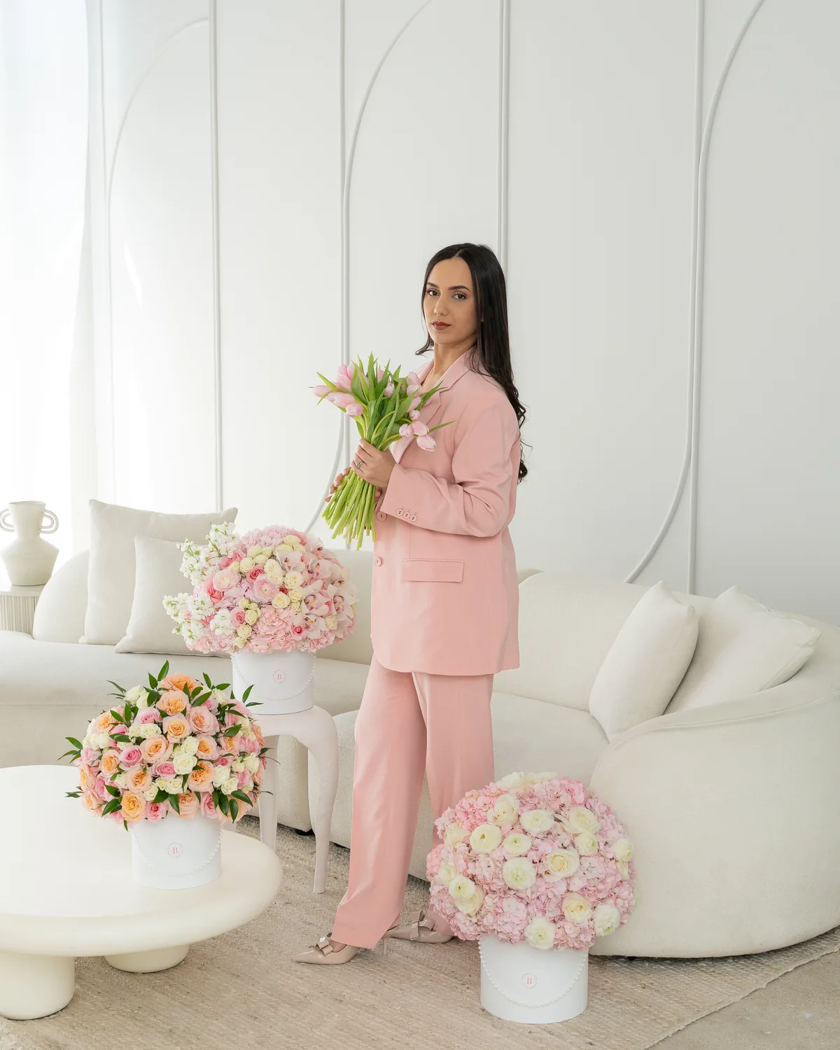 Branding portrait of a woman with a bouquet in a styled studio